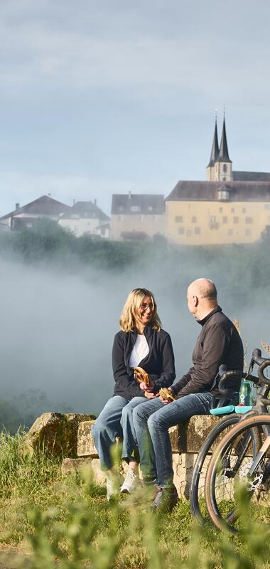 Fahrradfahrer bei einer kleinen Essenspause kurz vor der Stadt Bad Wimpfen mit dem Blauen Turm im Hintergrund, Bad Wimpfen