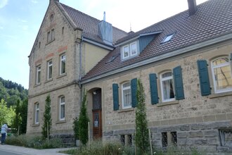 Außenansicht der alten Schule mit Natursteinen | © Touristikgemeinschaft Hohenlohe e. V. | Ferienwohnung Alte Schule
