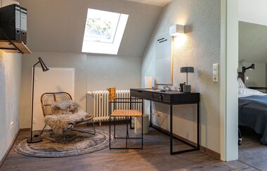 Modern eingerichtetes Zimmer mit Schreibtisch und gemütlichem Sessel im Ferienhaus Naturton | © Hohenlohe Schwäbisch Hall