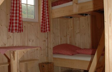 In den Radlerkojen steht ein Doppelbett und eine Sitzmöglichkeit | © Touristikgemeinschaft Hohenlohe e. V.  | Ferienhof Marina