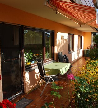 Terrasse der Ferienwohnung Abendsonne in Neckargemünd mit Sitzecke und vielen Blumen | © Ferienwohnung Abendsonne