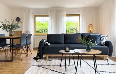 Wohnzimmer bestehend aus einer großen schwarzen Couch mit Couchtischchen und einem Esstisch mit mind. 3 Stühlen | © Neckar-Zaber-Tourismus e.V.