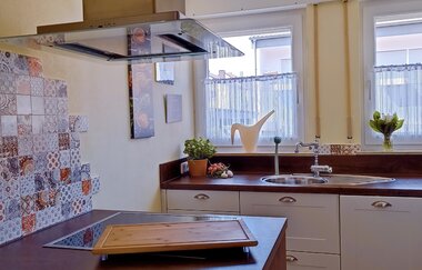 Küche 1 der Ferienwohnung: weiße Schränke, Spülbecken und Herd | © Neckar-Zaber-Tourismus e.V