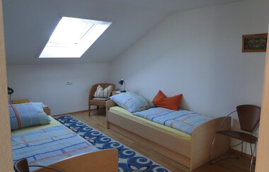 Zwei Einzelbetten mit jeweils einem Nachttischschrank mit Lampe und mehrere Stühle | © Neckar-Zaber-Tourismus e.V.