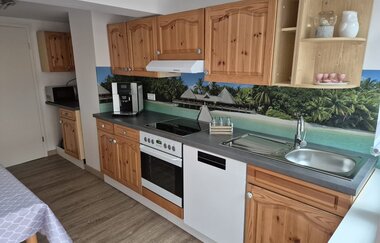 Küchenzeile mit Holzfront und Hinterwand mit Strandmotiv | © Wolf