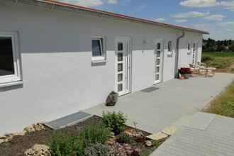 Außenansicht der Ferienwohnung; weißes recht flaches Gebäude mit mehreren Türen und rotem Dach | © Neckar-Zaber-Tourismus e.V.