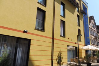 Der Gasthof von außen hat eine gelbe Fassade | © Touristikgemeinschaft Hohenlohe e. V. | Gasthof Engel