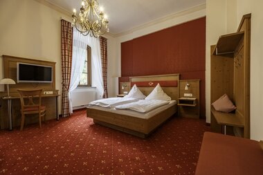 Gemütliches Doppelbett mit Fernseher und Kofferablage | © Touristikgemeinschaft Hohenlohe e. V. | Dominik Rau