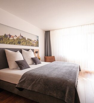 Komfortdoppelzimmer mit Doppelbett und Schreibtisch | © Touristikgemeinschaft Hohenlohe e. V. | Ingrid Düstersiek-Schuster