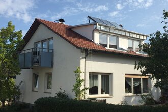 Ein weißes Haus mit Balkon und Garten. | © Ilse Hofmann