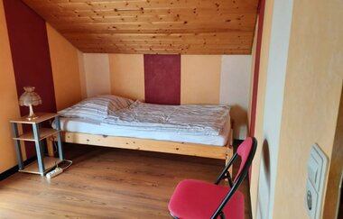 Im Schlafzimmer steht ein Bett und ein Stuhl | © Touristikgemeinschaft Hohenlohe e. V.