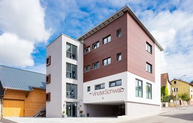 Das Vinotel ist modern gebaut und weiß und rosa gestrichen | © Touristikgemeinschaft Hohenlohe e. V. | Weingut Heinz J. Schwab
