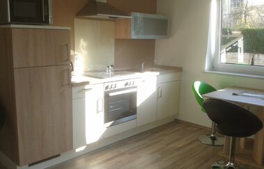 Ferienwohnung Küchenzeile mit kleinem Tisch, Stühlen und Fenster