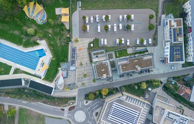 Luftaufnahme des Wohnmobilstellplatzes mit angrenzendem Freibad und Gebäuden