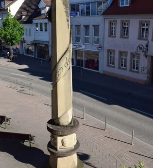 Steinerne Säule mit Inschriften an einer Straße mit Gebäuden | © Stadtverwaltung Sinsheim