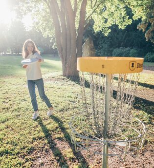 Frau spielt DiscGolf im Kurpark in Bad Rappenau | © @Stadt Bad Rappenau I Chris Frumolt