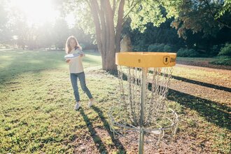 Frau spielt DiscGolf im Kurpark in Bad Rappenau | © @Stadt Bad Rappenau I Chris Frumolt