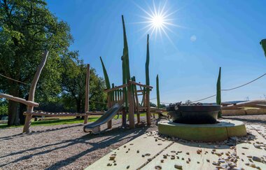 Spielplatz mit Klettergerüst und Rutsche unter blauem Himmel und Sonnenschein. | © Michael Kuehneisen