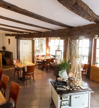 Der Innenraum im Restaurant ist mit rustikalem Ambiente mit Holztischen ausgestattet. | © Touristikgemeinschaft Hohenlohe e. V. | Jägers Landhaus Rössle