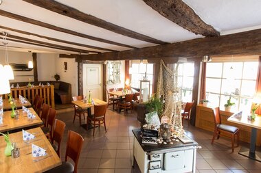Der Innenraum im Restaurant ist mit rustikalem Ambiente mit Holztischen ausgestattet. | © Touristikgemeinschaft Hohenlohe e. V. | Jägers Landhaus Rössle