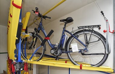 Blaues E-Bike steht gesichert in einem Fahrradanhänger