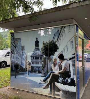 Auf die Toilette ist ein Bild mit zwei Frauen auf einer Bank aufgedruckt | © Touristikgemeinschaft Hohenlohe e. V.
