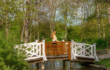 Eine Frau läuft über eine kleine Holzbrücke