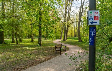 Wanderwege führen durch den Schlosspark, gekennzeichnet mit Schilder an Laternenpfosten