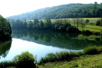 Stausee mit grünen Wiesen | © Touristikgemeinschaft Hohenlohe e. V. | Gemeinde Mulfingen