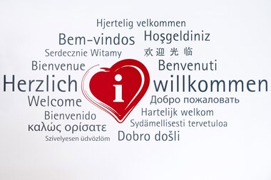 Rotes Herz, umgeben von dem Schriftzug "Herzlich Willkommen", in verschiedenen Sprachen. | © Tourist Information Schwetzingen