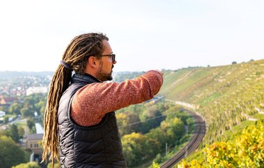 Winzer Christian Dautel zeigt in der steilen Terrassenlage Niedernberg über die Weinberge.