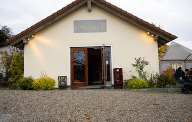 Außenansicht der Vinothek vom Weingut Ungerer, mit einladender offener Tür | © Touristikgemeinschaft Hohenlohe e.V. | Weingut Ungerer