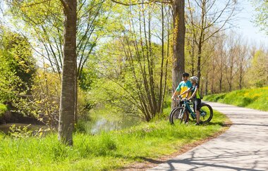 BühlerSchleife Ost - zwei Radfahrer halten an der Bühler und schauen auf den Fluss | © Arbeitsgemeinschaft Kocher-Jagst-Radweg