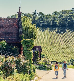 Zwei wandernde Frauen vor einem Weinbergshäuschen am Wartberg Heilbronn