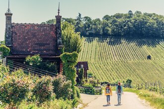Zwei wandernde Frauen vor einem Weinbergshäuschen am Wartberg Heilbronn