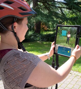Frau die ein Tablet hält und die Augmented Reality App Weitersehen nutzt | © Landratsamt Rhein-Neckar-Kreis