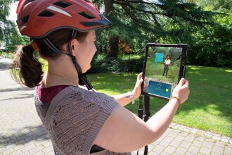 Frau die ein Tablet hält und die Augmented Reality App Weitersehen nutzt | © Landratsamt Rhein-Neckar-Kreis